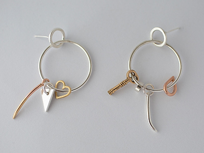 Jo irvine metal hoop earrings with tiny keys and hearts dangling off them