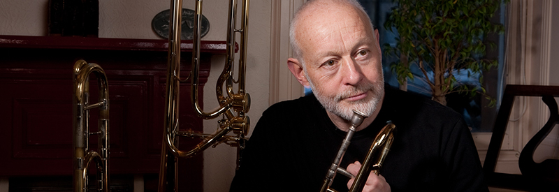 John Kenny sits with musical instruments around him