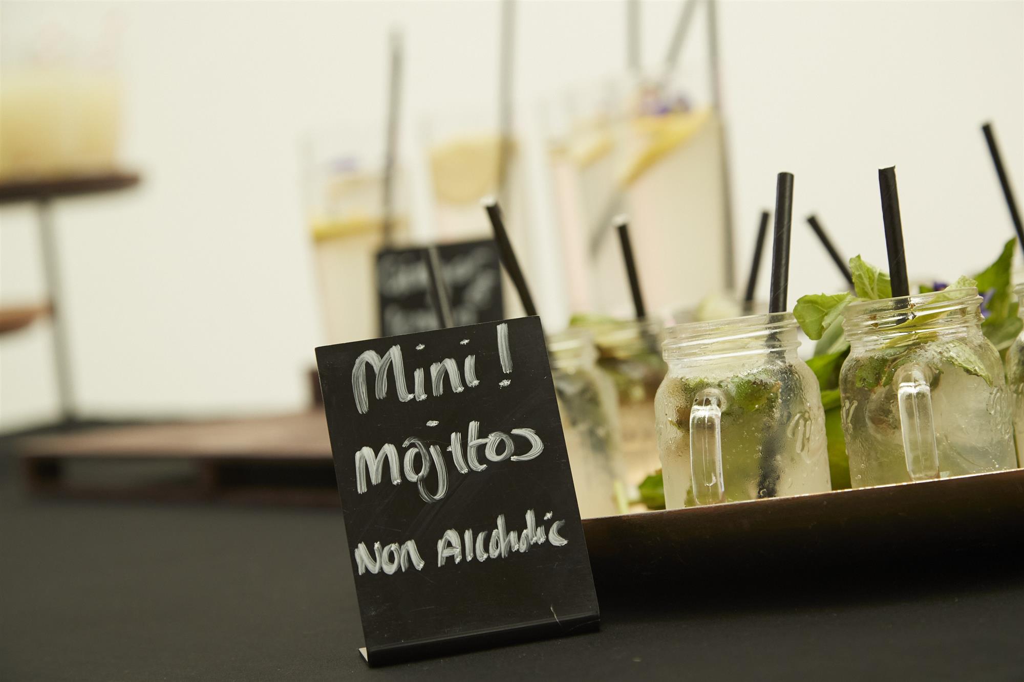 A display of non-alcoholic mojitos in mini mason jars