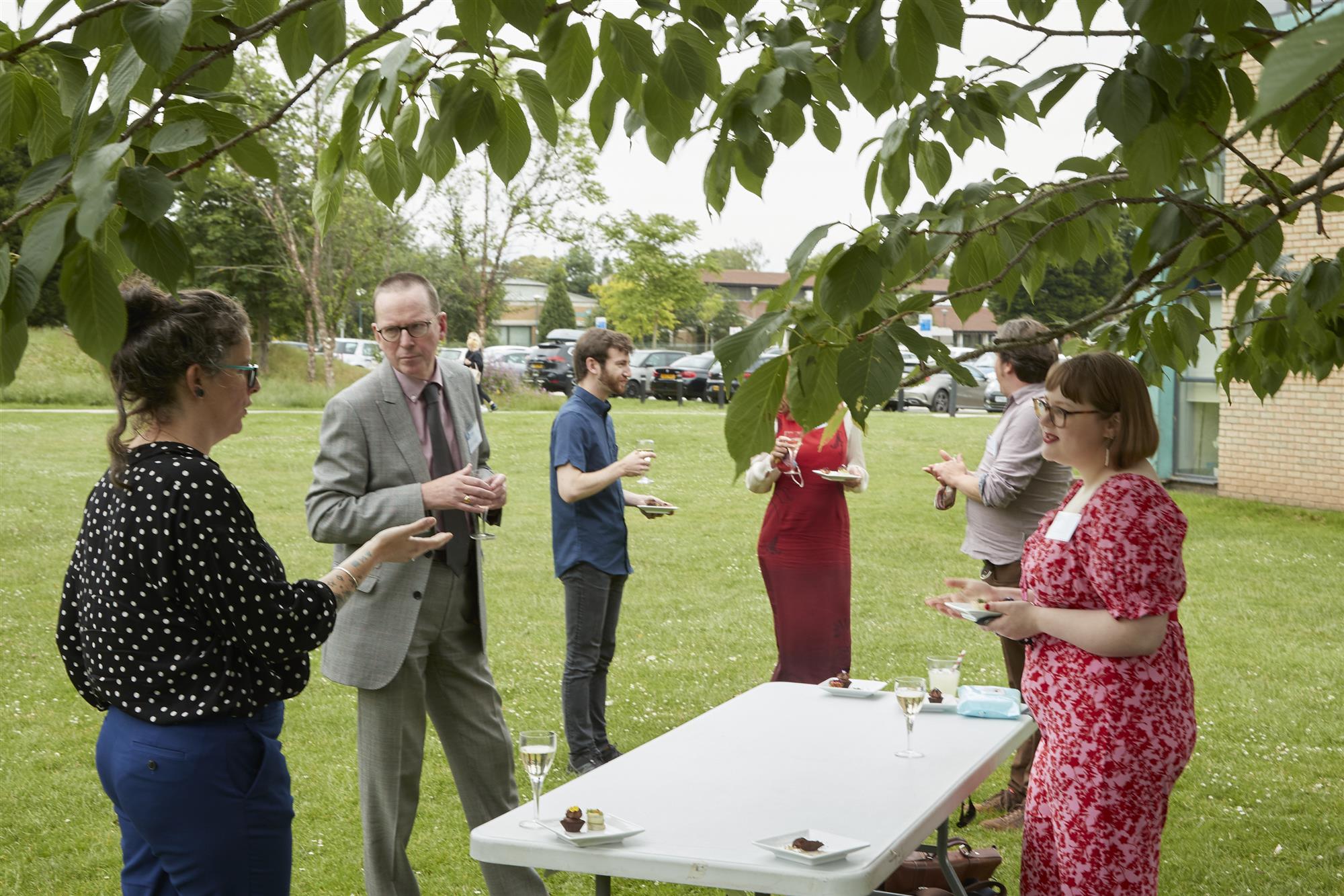 Professor Jeremy Gregory in conversation with members of the Creative Pathways programme in Highfields Park, with the Lakeside Pavilion in the background