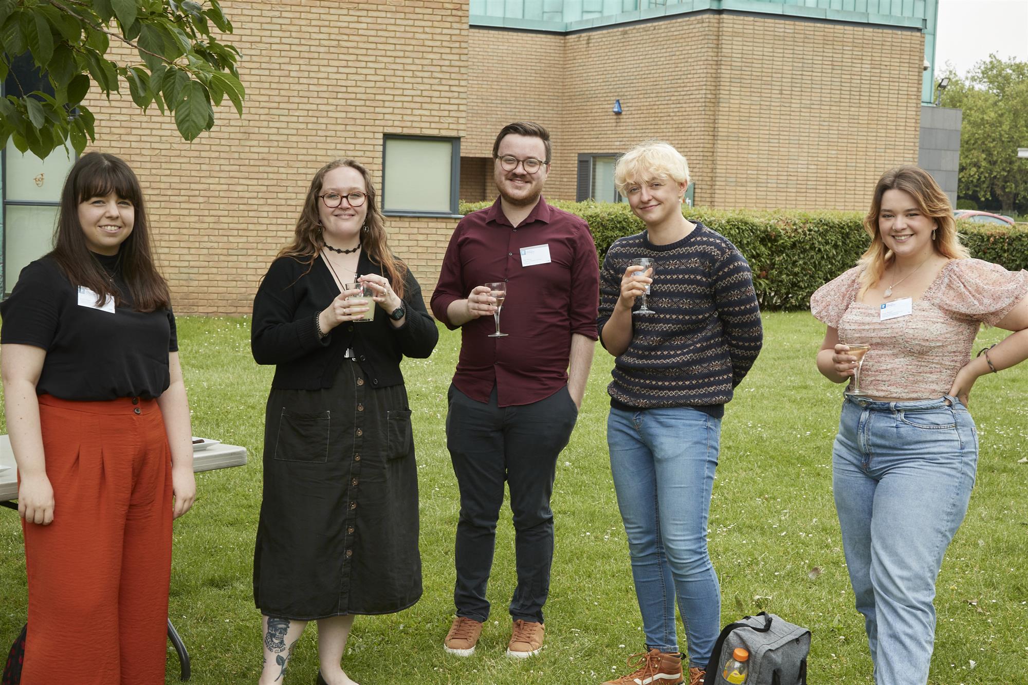 Members of the 2019-20 cohort hold drinks and smile at the camera