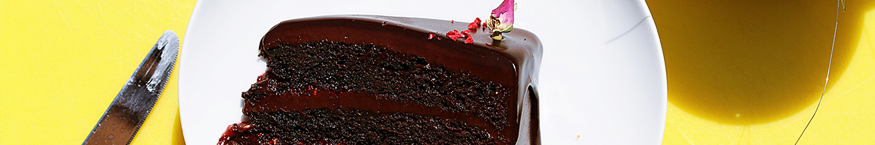 Slice of chocolate cake on plate on yellow table