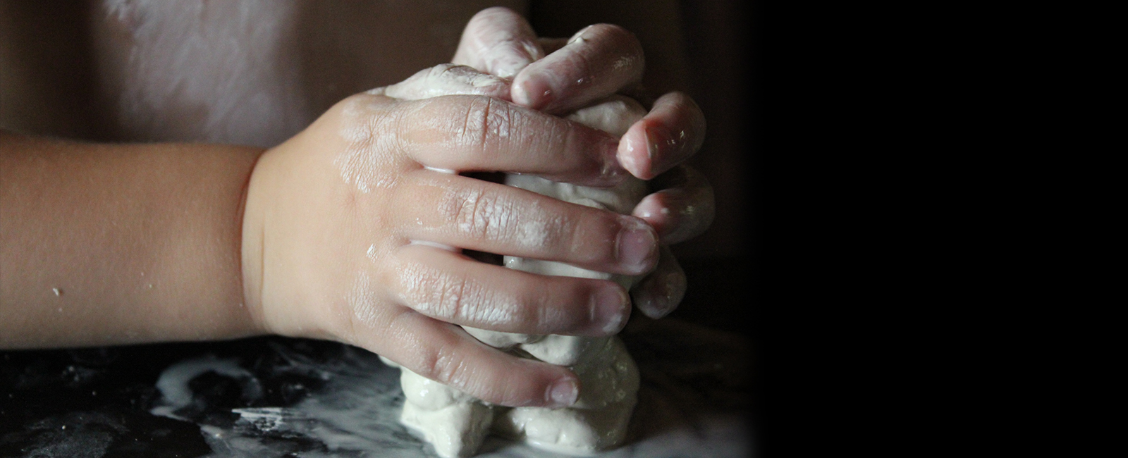 a child's hands holding clay