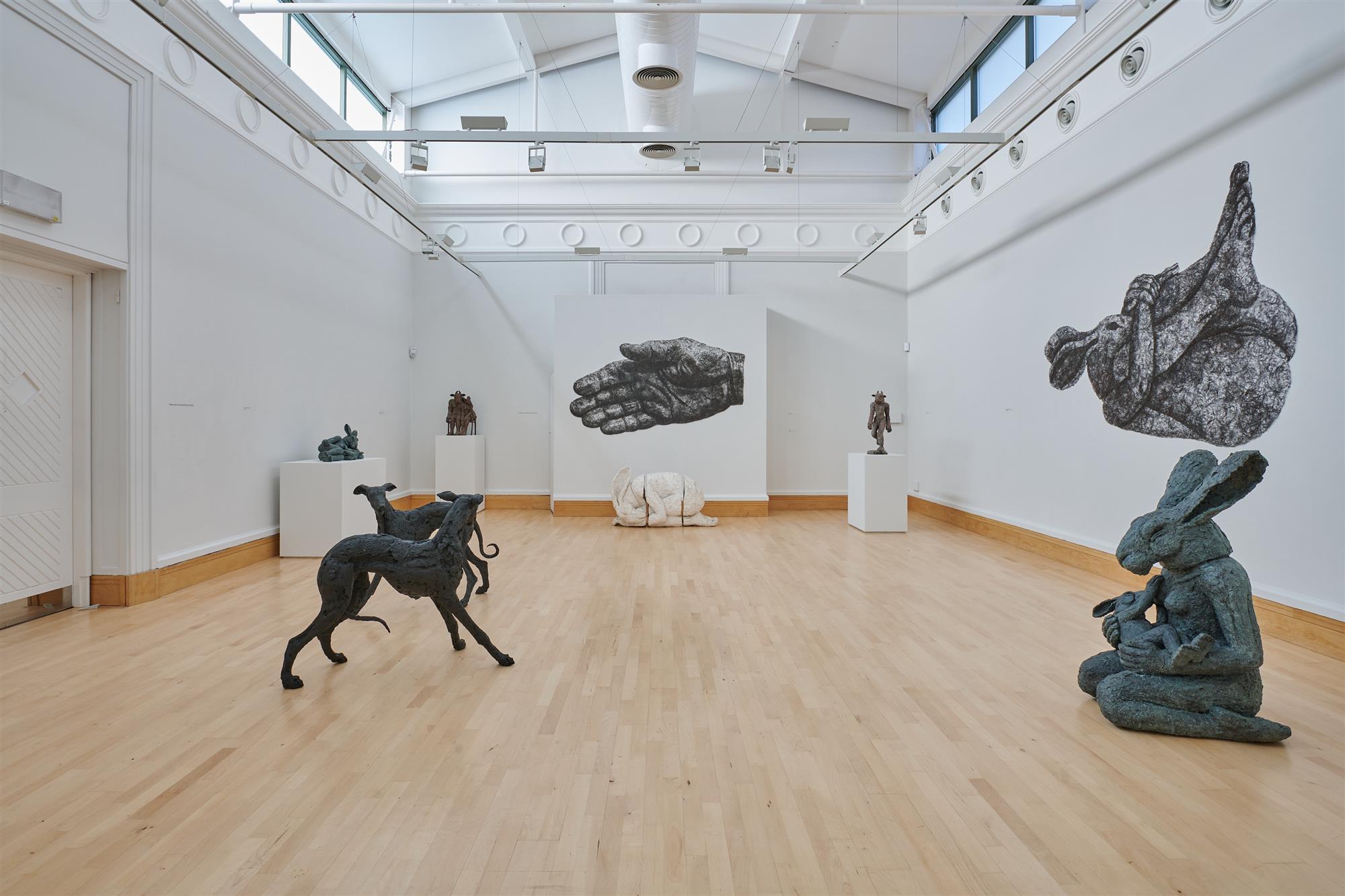 A gallery space filled with bronze sculptures