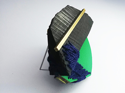 Sculptural jewellery piece displaying a multitude of textures in green and blue 