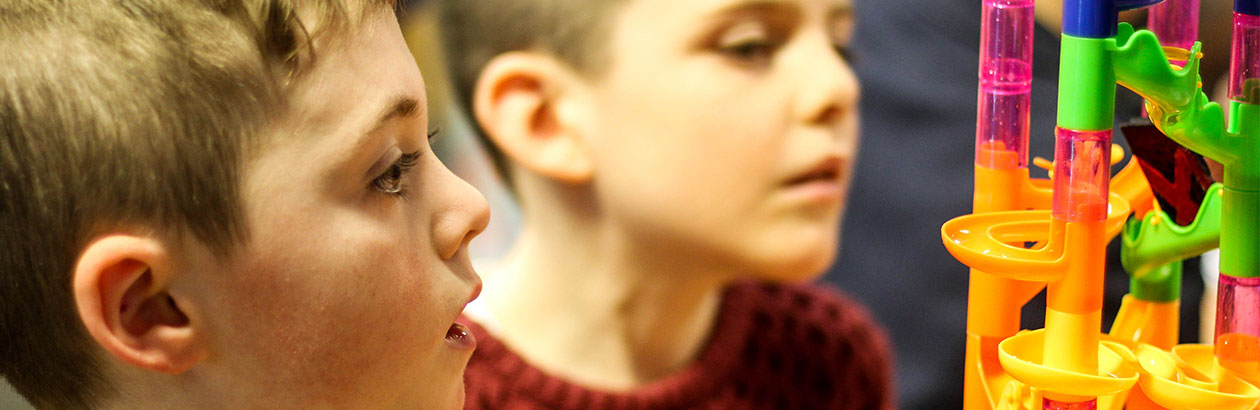 Two children looking at a plastic toy