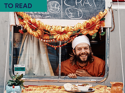 Man poking head out of food van with food on table in front Keywords: TO READ