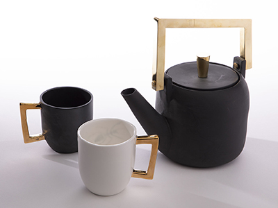 Photo of a black and white copper tea set with two mugs and a teapot