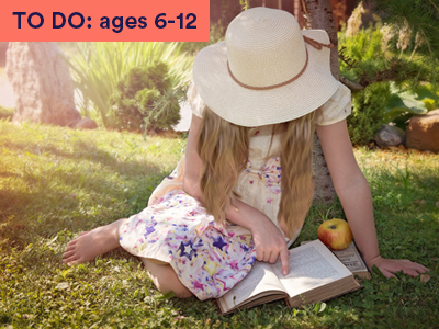 a little girl reading outdoors. Keyword in the corner FOR FAMILIES