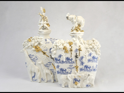 Ornately patterned white vases covered in gold and white three dimensional animals