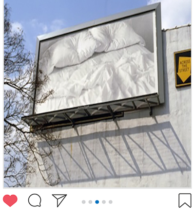 Photograph of billboard of an empty bed by Felix Gonzalez-Torres