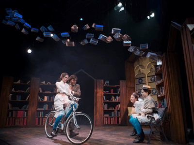Girl on bicycle in Blue Stockings in the Djanogly Theatre