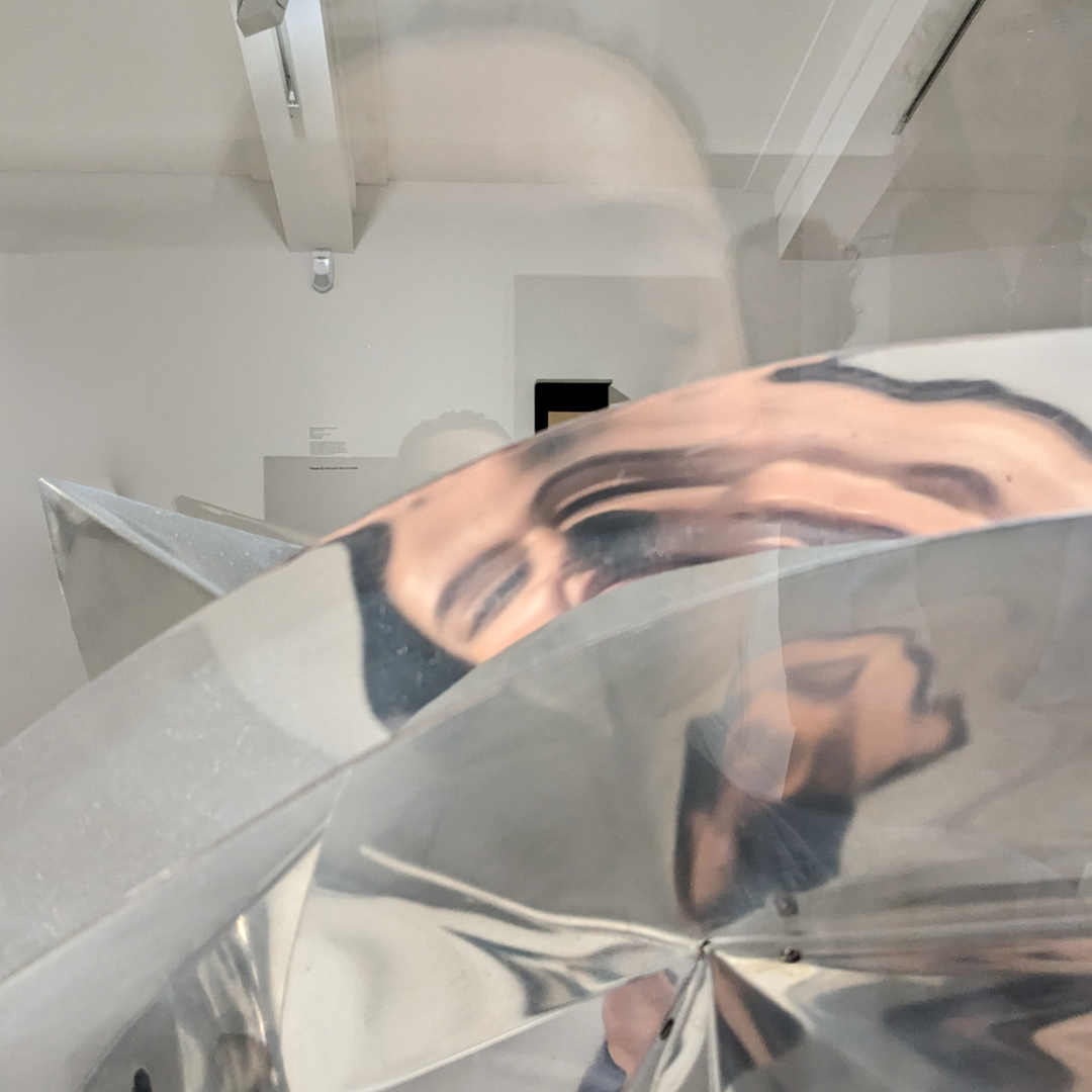 A lady's face distorted in a metal sculpture